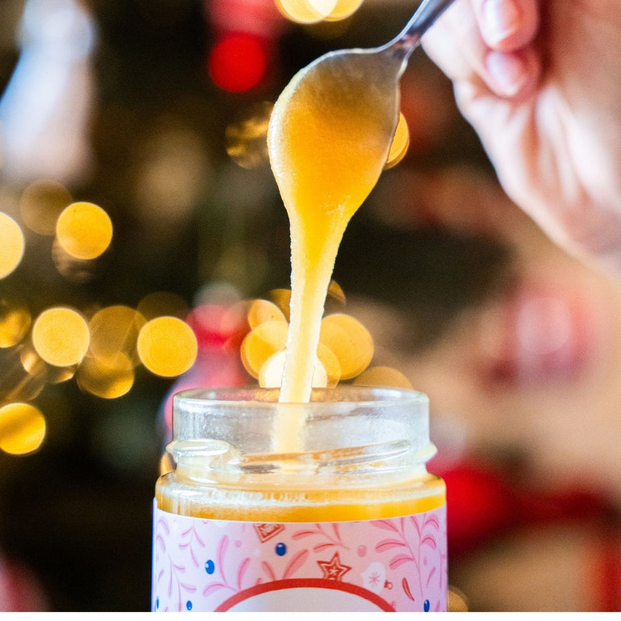 Pot de miel décoré pour Noël avec un ruban festif