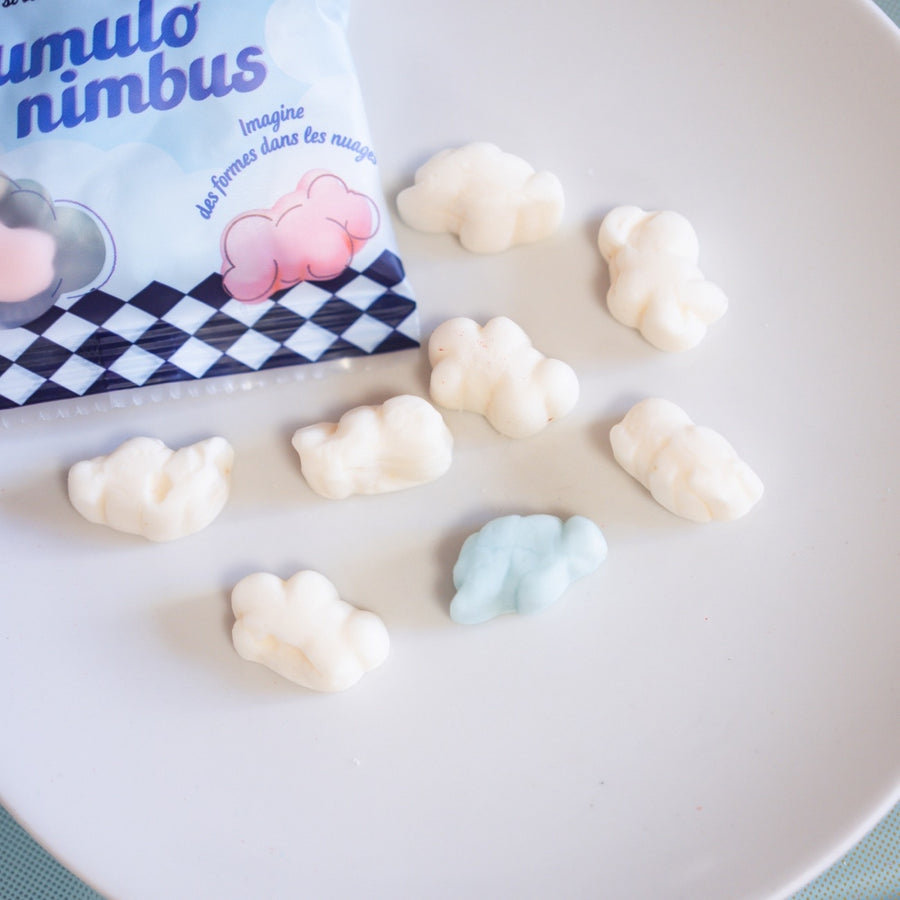 Guimauves nuage moelleuses, dont une bleue, éparpillées près du sachet