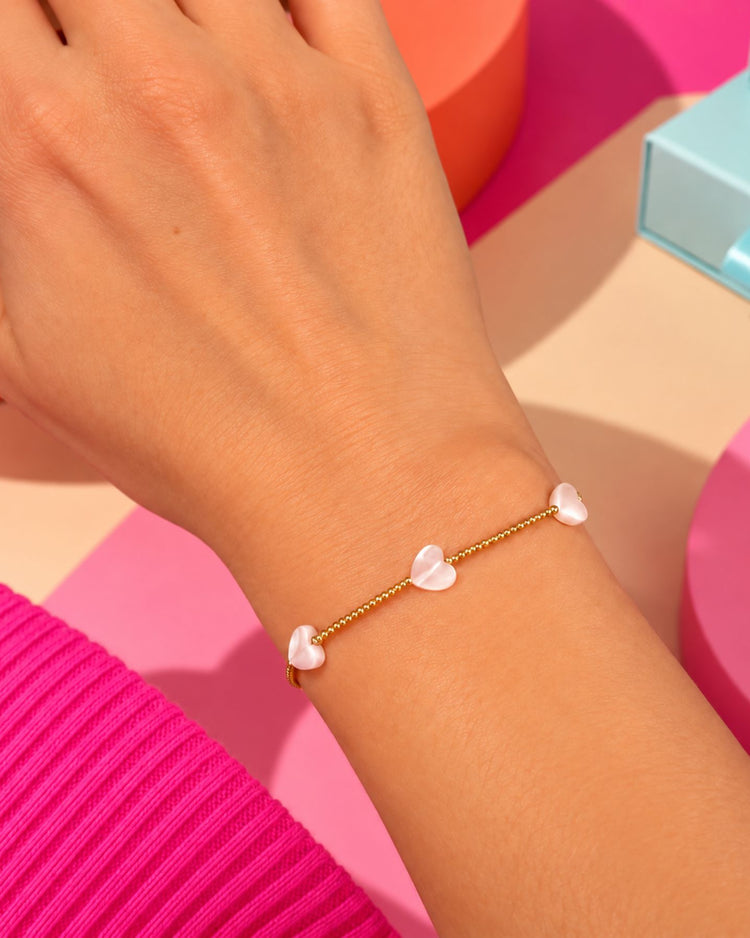 Bracelet doré avec petits cœurs en nacre, vue de près