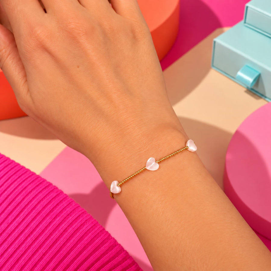 Bracelet doré avec petits cœurs en nacre, vue de près