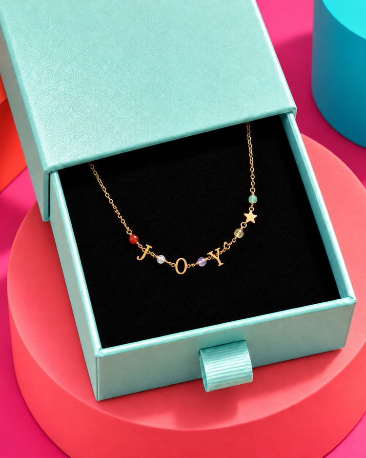 Bracelet doré JOY aux cristaux multicolores, présenté dans un écrin ouvert