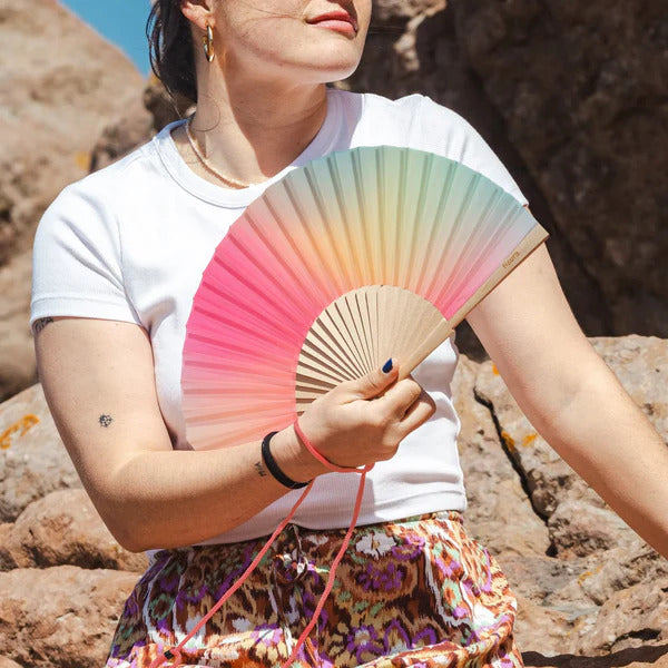Éventail arc-en-ciel ouvert, motifs colorés vibrants.