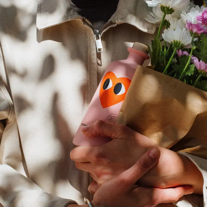 Bouteille d'huile d'olive avec étiquette colorée et design élégant.