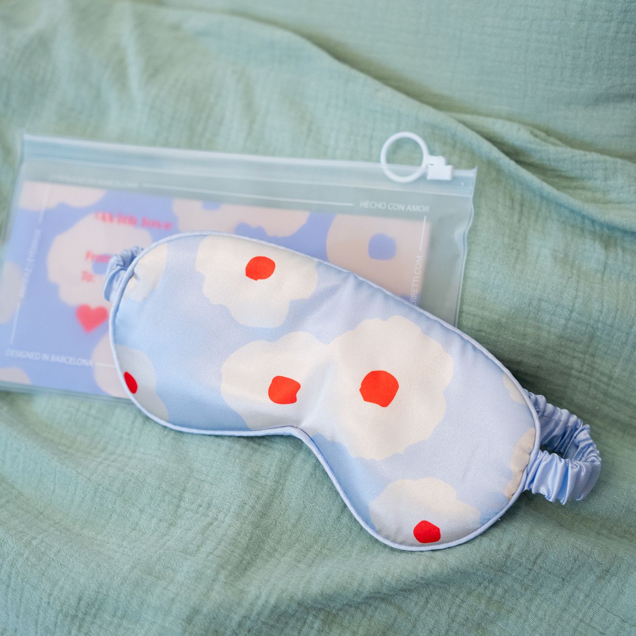Masque de sommeil fleuri en tissu satiné, vue de face.