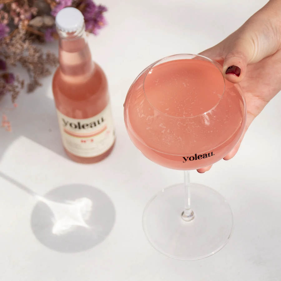 Bouteille de Yoleau avec étiquette cranberry sur fond clair.