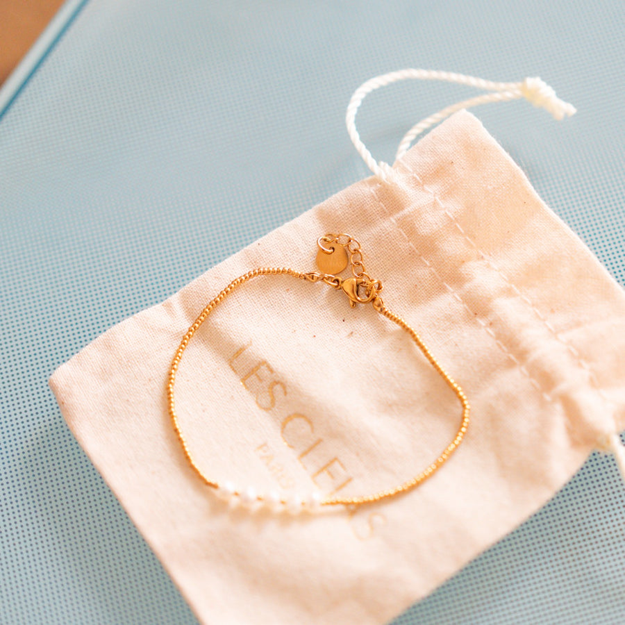 Bracelet délicat avec perles blanches sur chaîne dorée