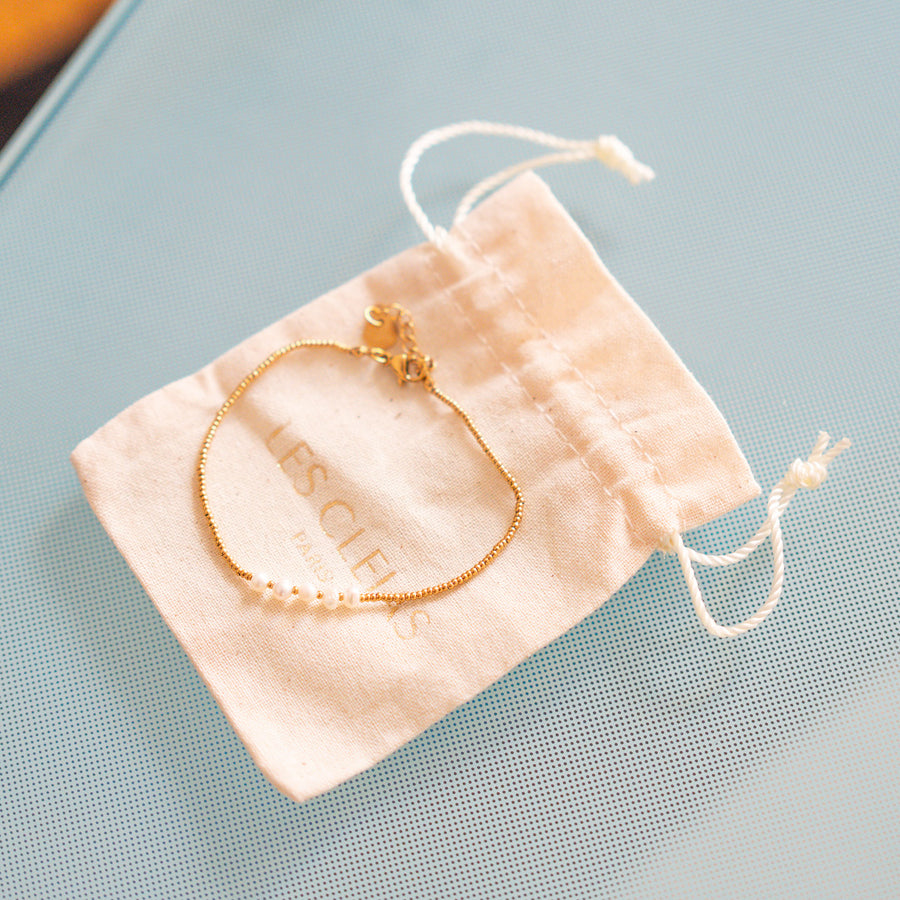 Bracelet délicat avec perles blanches sur chaîne dorée