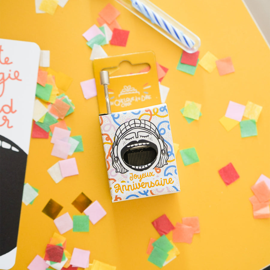 Boîte à musique avec motif de gâteau d'anniversaire coloré.