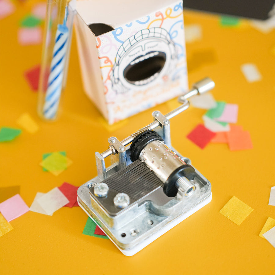 Boîte à musique avec motif de gâteau d'anniversaire coloré.