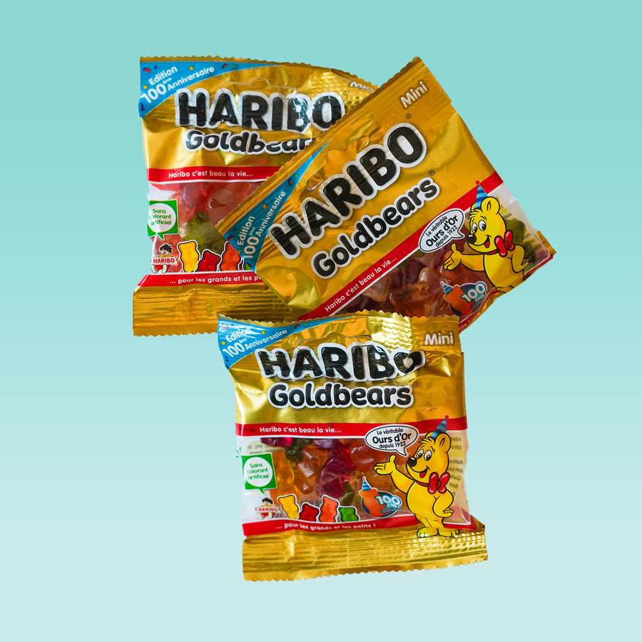 Cinq sachets d'oursons Haribo avec motifs colorés.