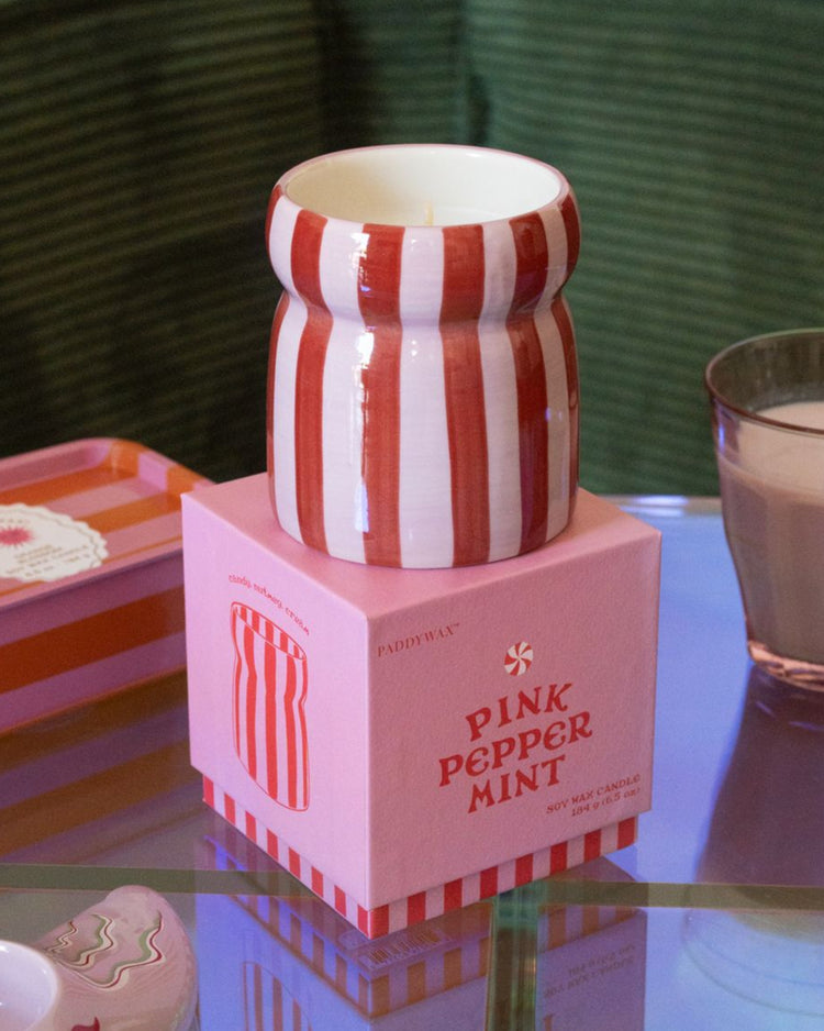 Bougie Color Pop avec rayures colorées et pot en verre.
