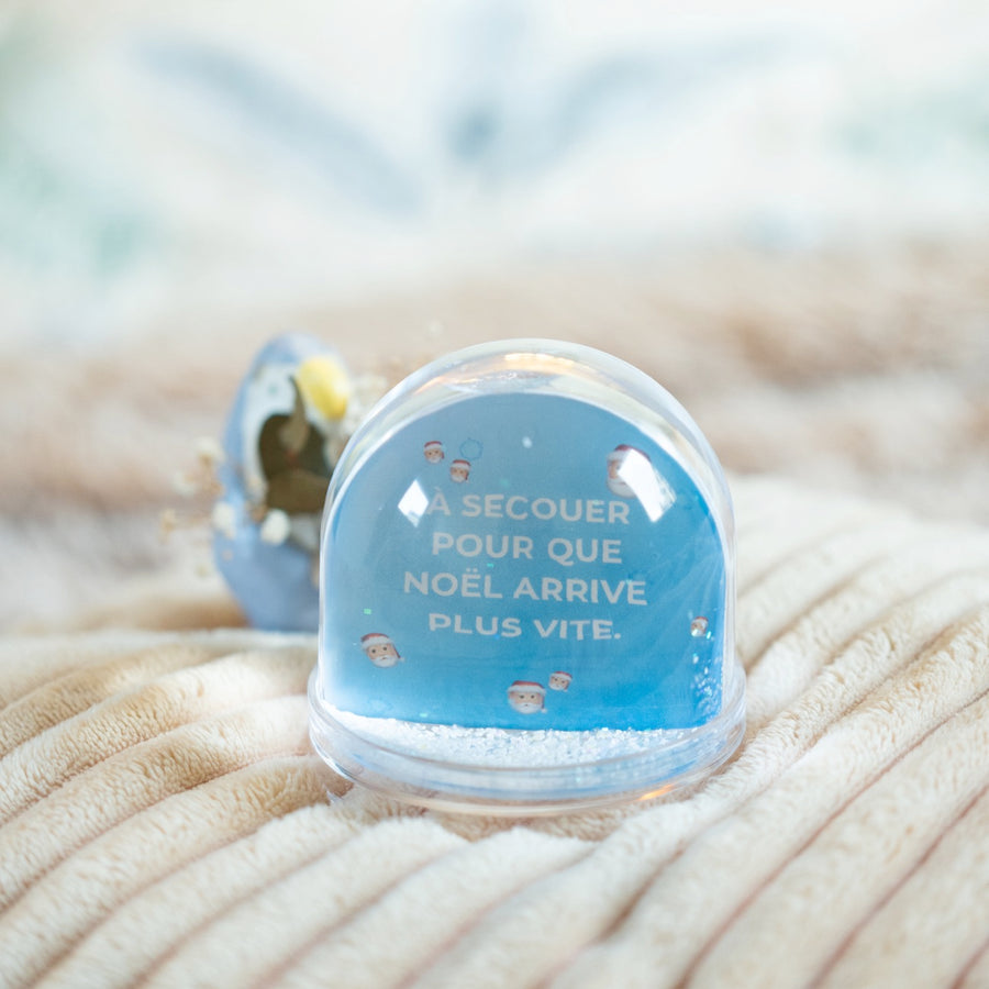 Boule à neige avec flocons scintillants en gros plan