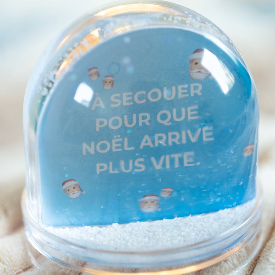 Boule à neige avec flocons scintillants en gros plan.