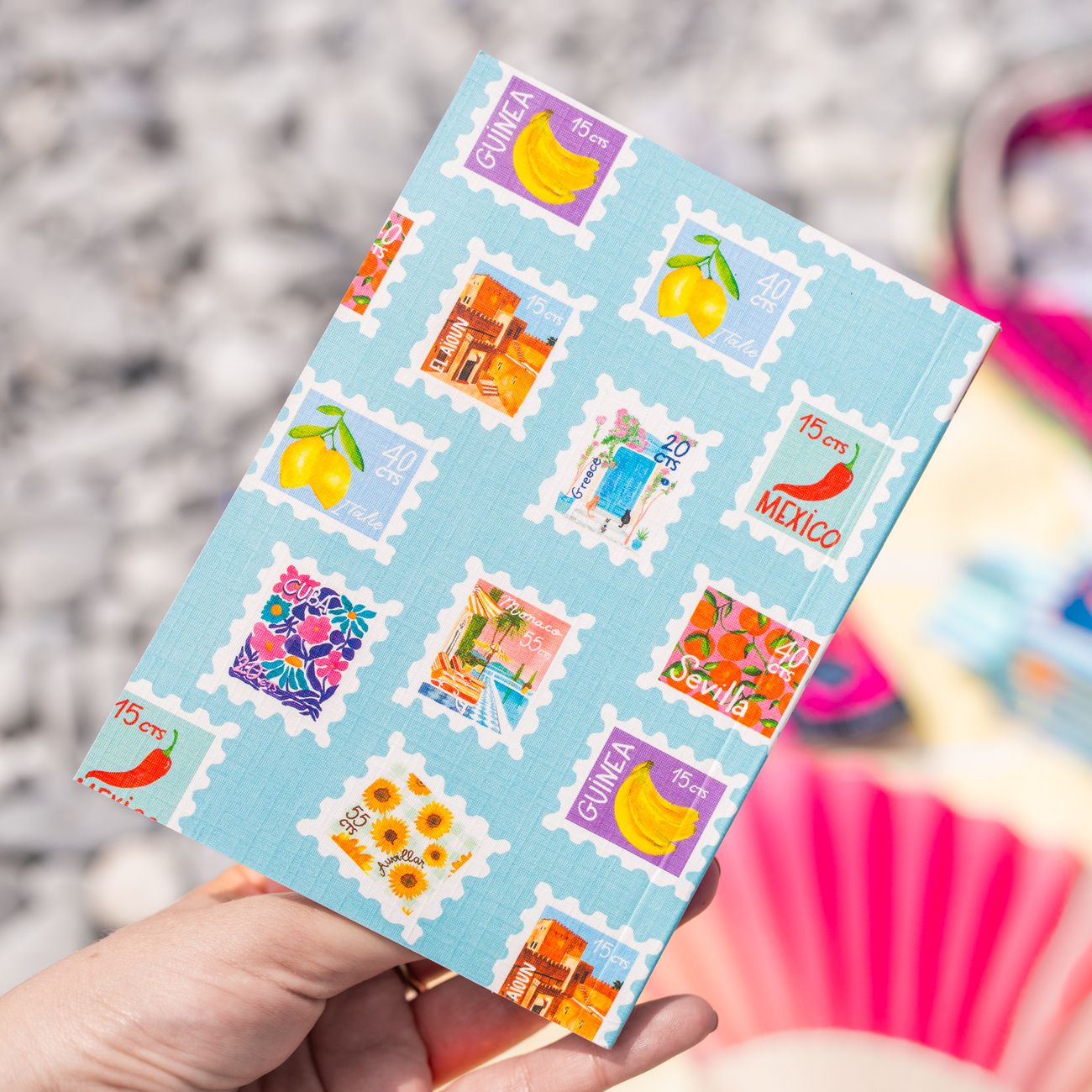 Petit carnet avec motifs de timbres colorés sur la couverture