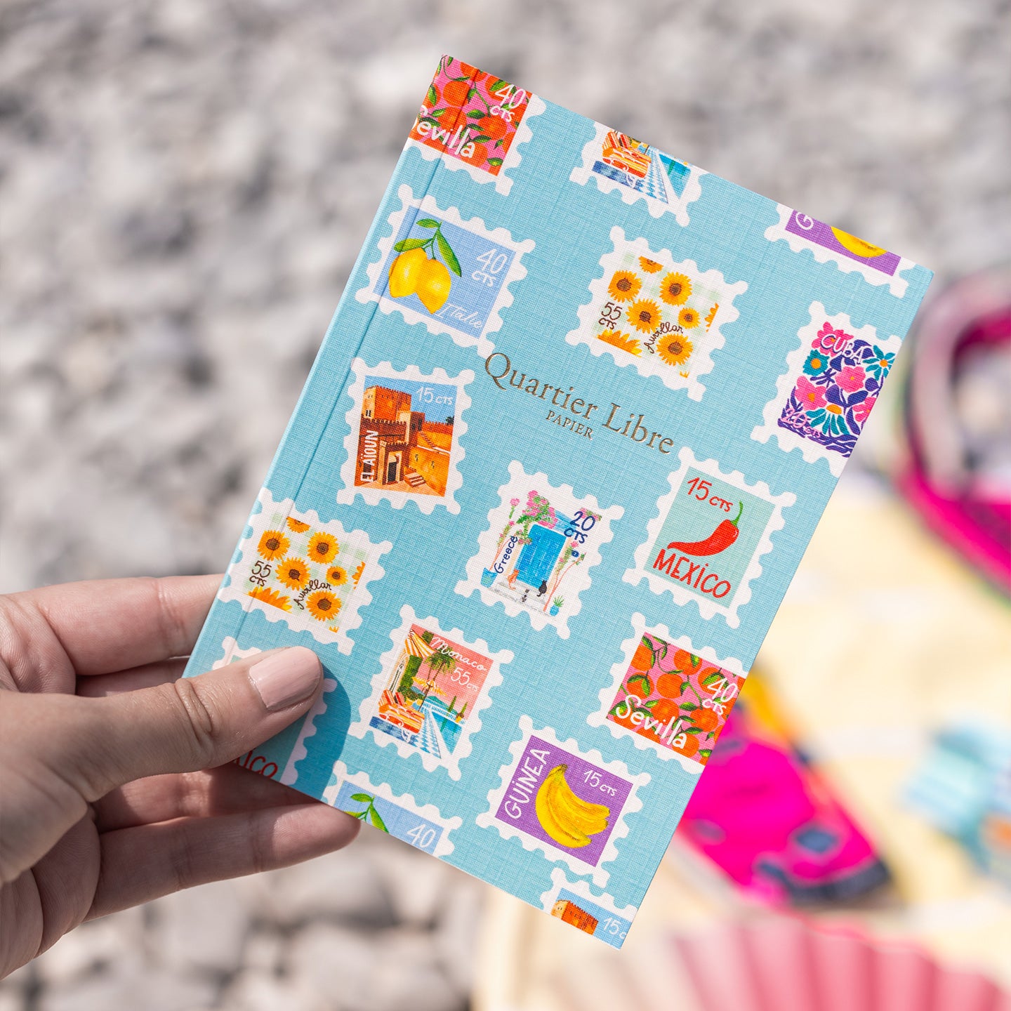 Petit carnet avec motifs de timbres colorés sur la couverture