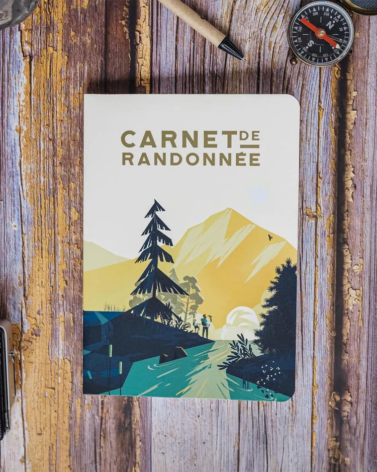 Carnet de randonnée ouvert avec pages blanches et couverture texturée.