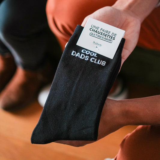 Chaussettes noires avec motif 'Cool Dads Club' en gros plan.