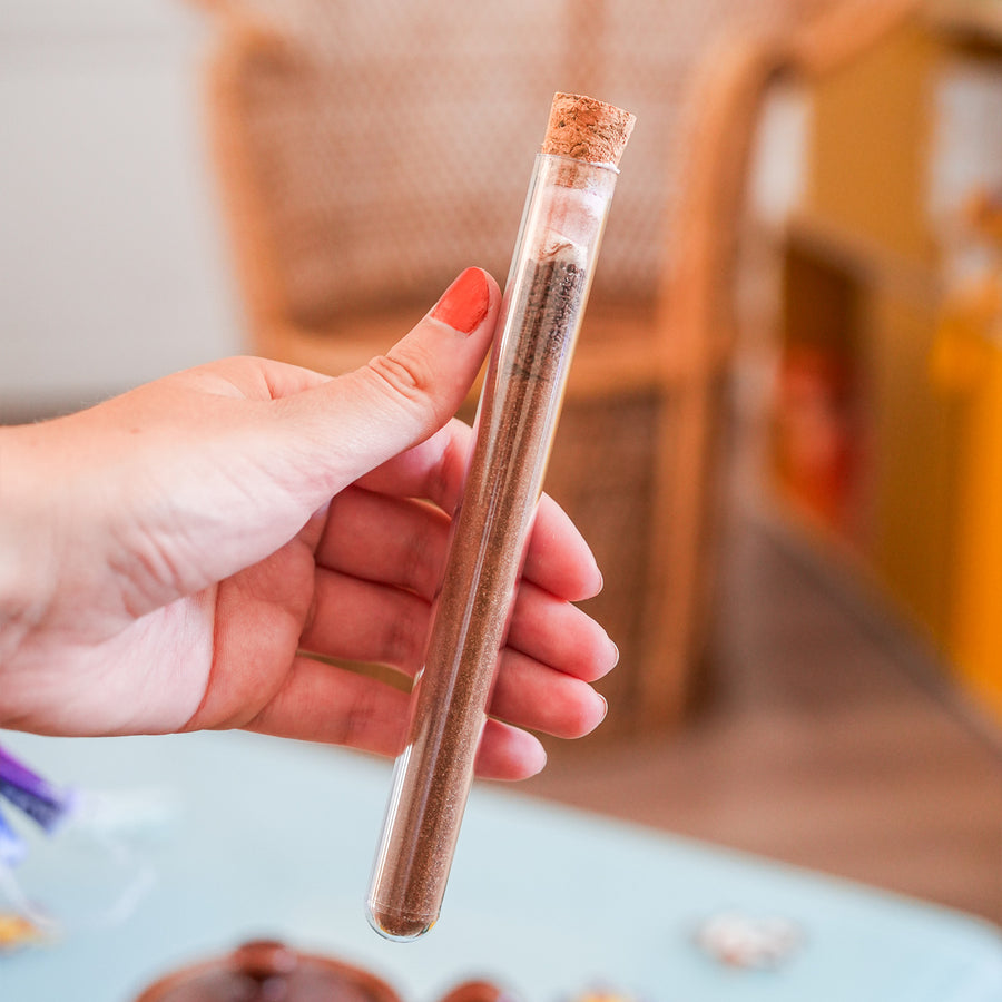 Tube à chocolat chaud avec étiquette colorée et bouchon doré.