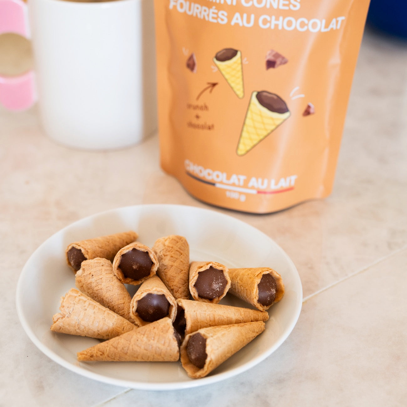 Mini cônes fourrés au chocolat sur fond clair, vue de dessus.