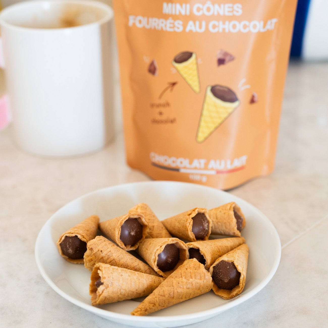 Mini cônes fourrés au chocolat sur fond clair, vue de dessus.