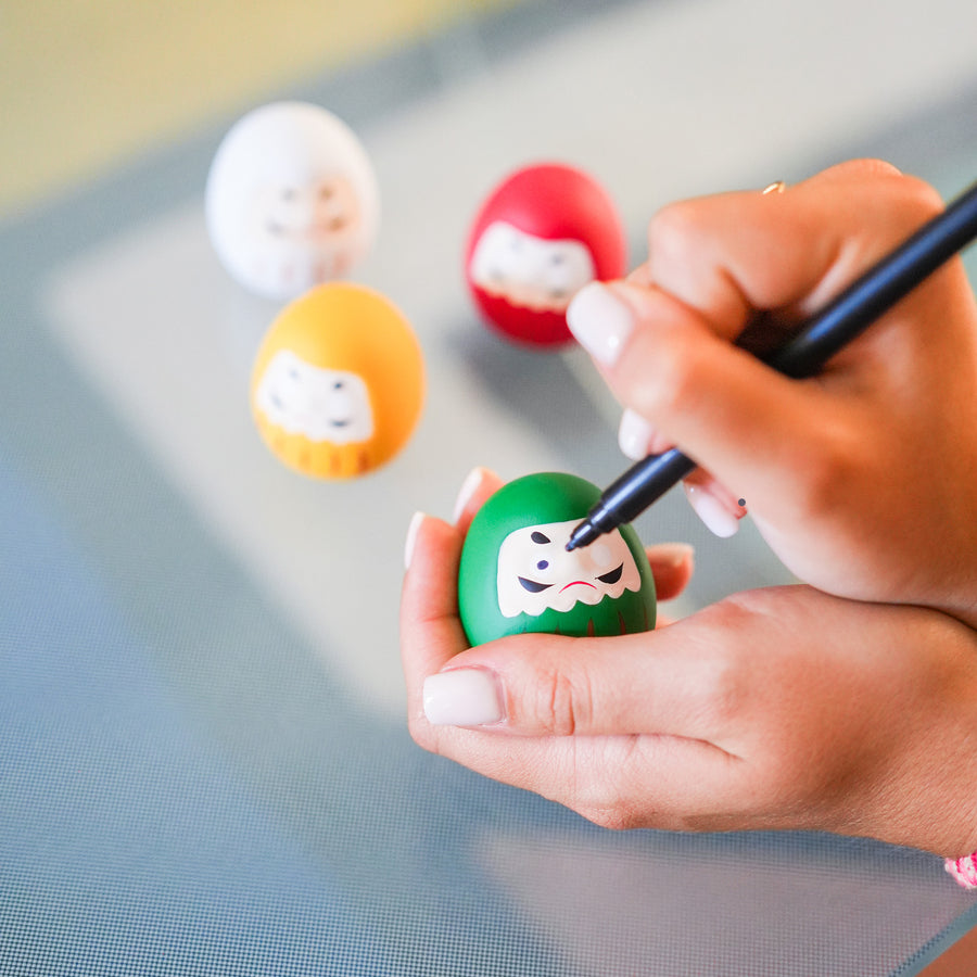 Daruma japonais en vue rapprochée, détails des yeux vides.