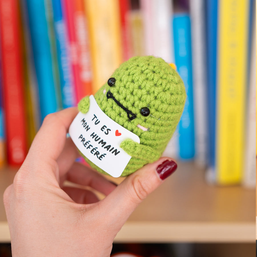 Dinosaur en crochet tenant une pancarte affectueuse.