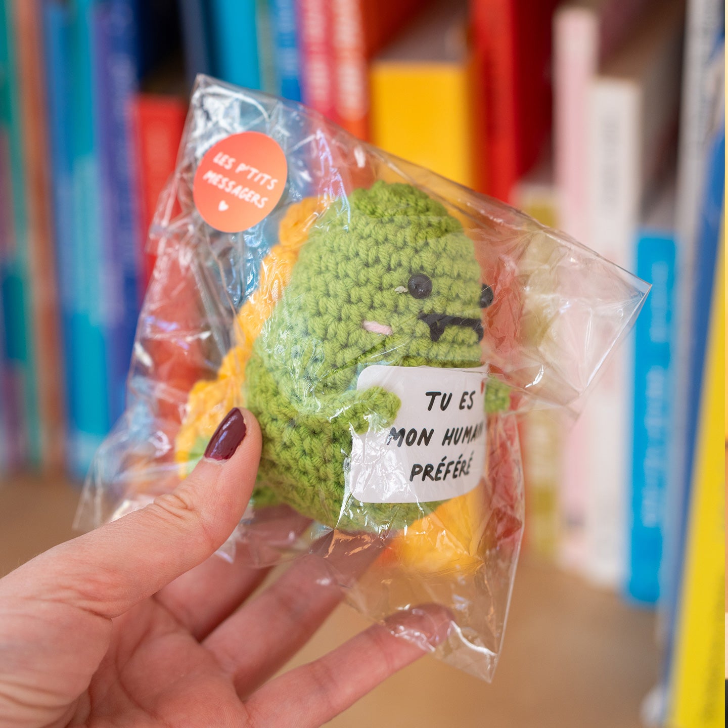 Dino en crochet tenant une pancarte avec un message affectueux.