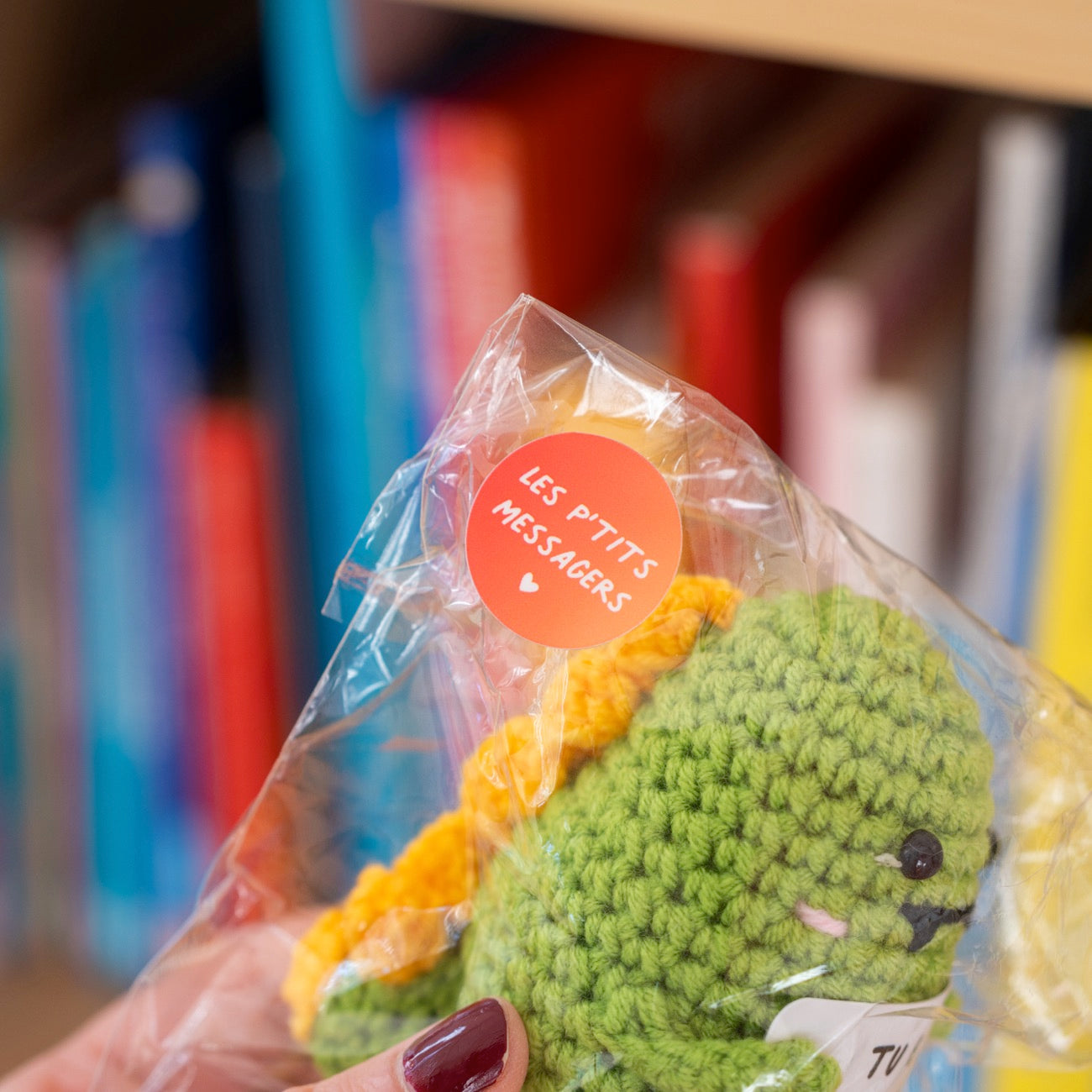 Dino en crochet tenant une pancarte avec un message affectueux.