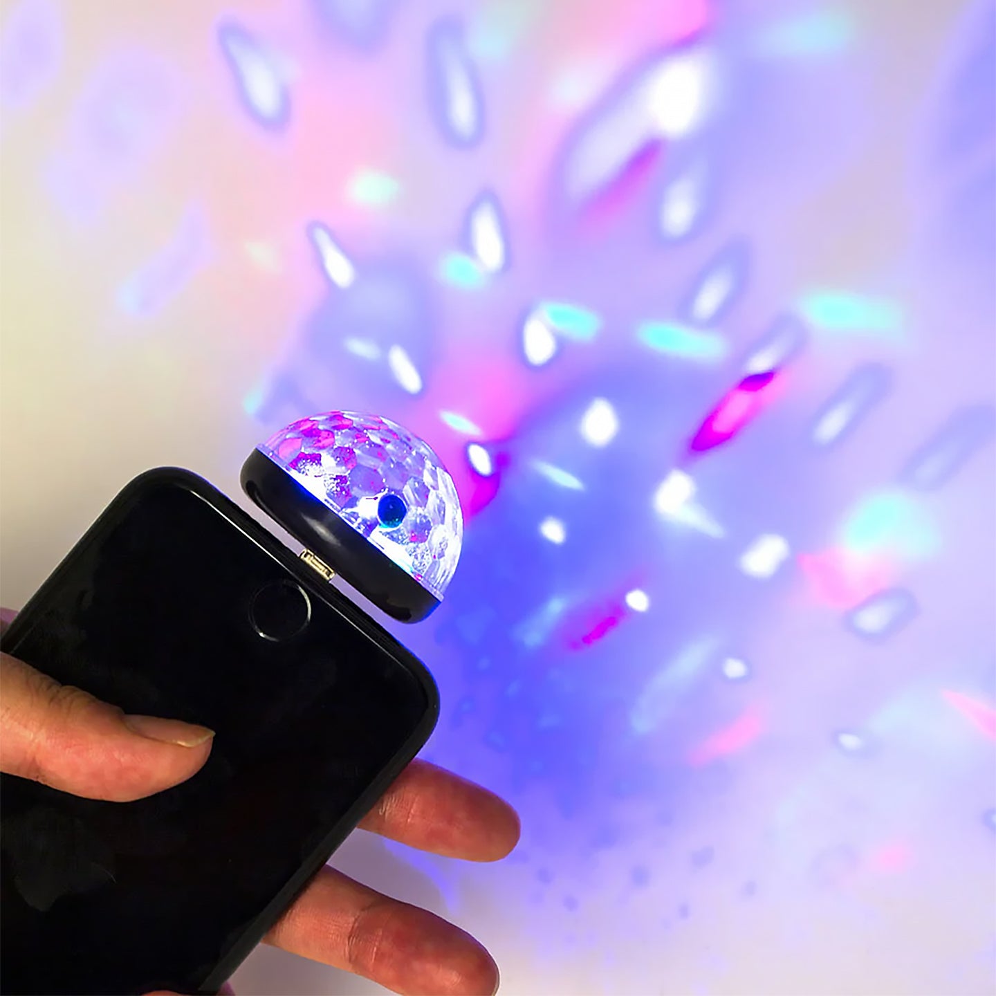 Boule disco lumineuse projetant des lumières colorées.