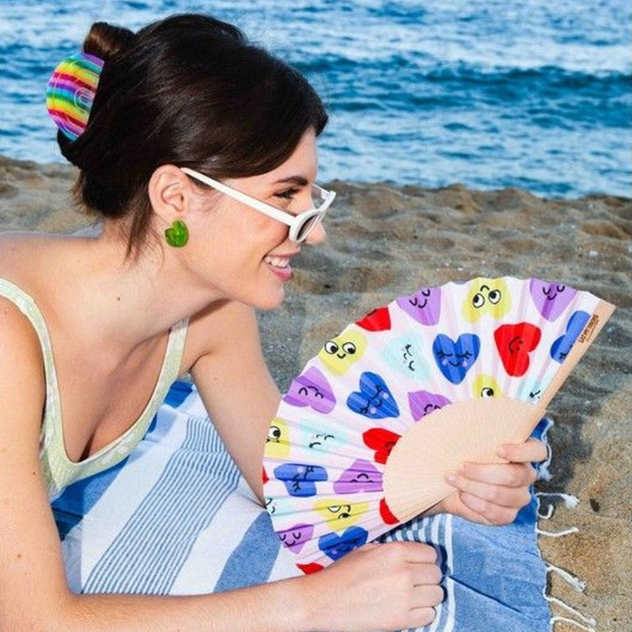 Éventail compact décoré de cœurs, ouvert en position élégante