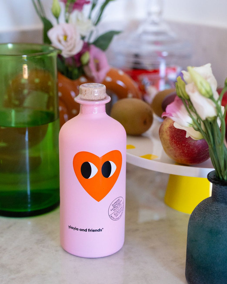 Bouteille d'huile d'olive avec motif cœur sur fond clair.