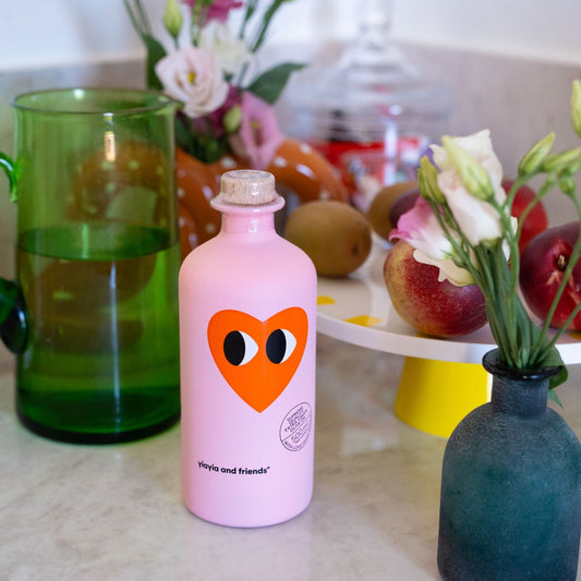 Bouteille d'huile d'olive avec motif cĆur sur fond clair.