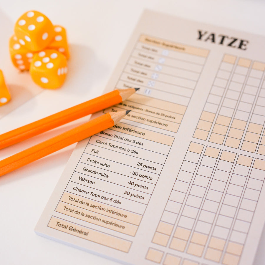 Boîte de jeu de Yahtzee avec dés colorés en vue de dessus.