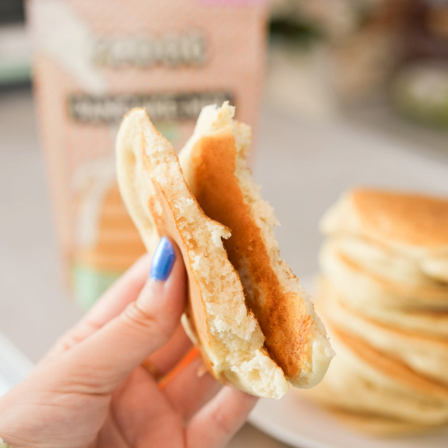 Kit DIY pancakes avec ustensiles et mélange en vue aérienne.