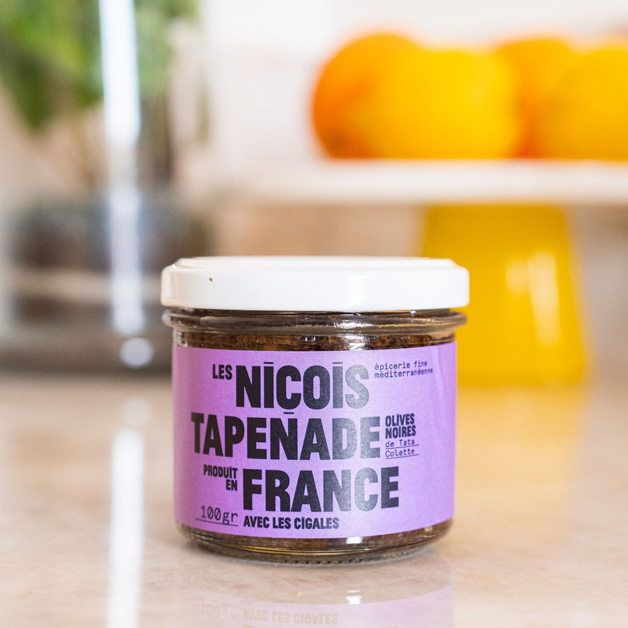 Pot de tapenade noire avec texture crémeuse et olives visibles.