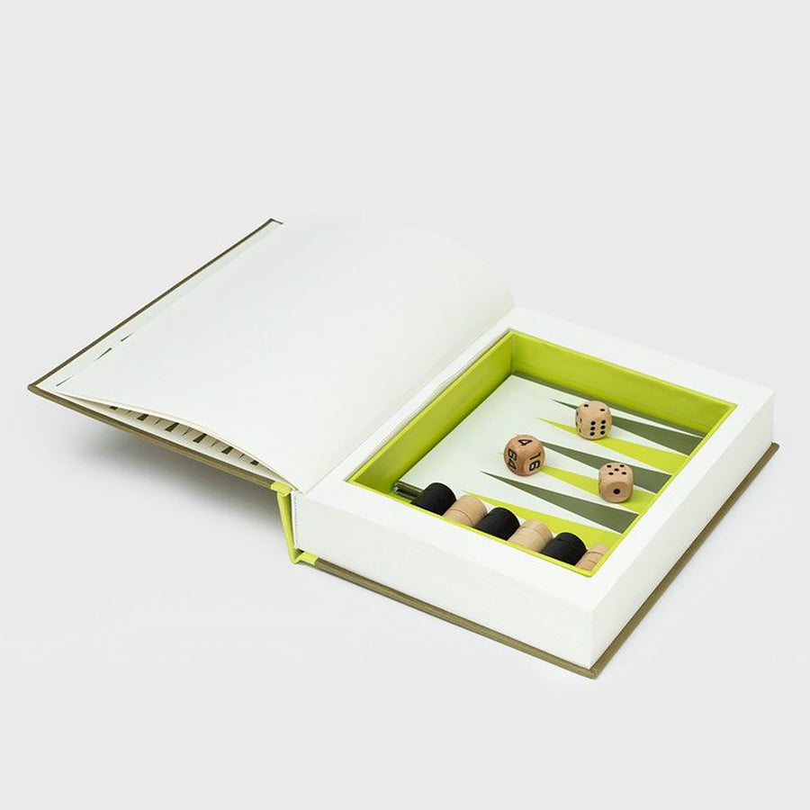 Livre ouvert révélant un backgammon avec pions colorés.