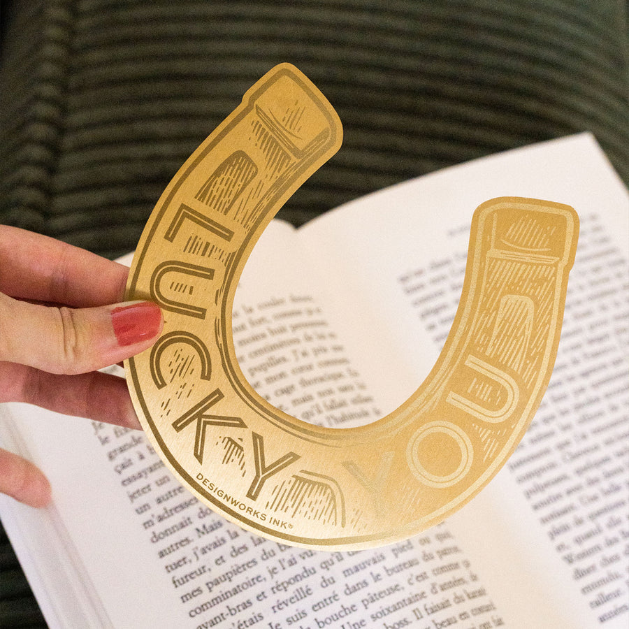 Marque-page en laiton en forme de fer à cheval, vue de côté.