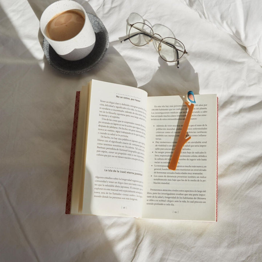 Marque-pages avec un oiseau coloré sur le coin d'un livre