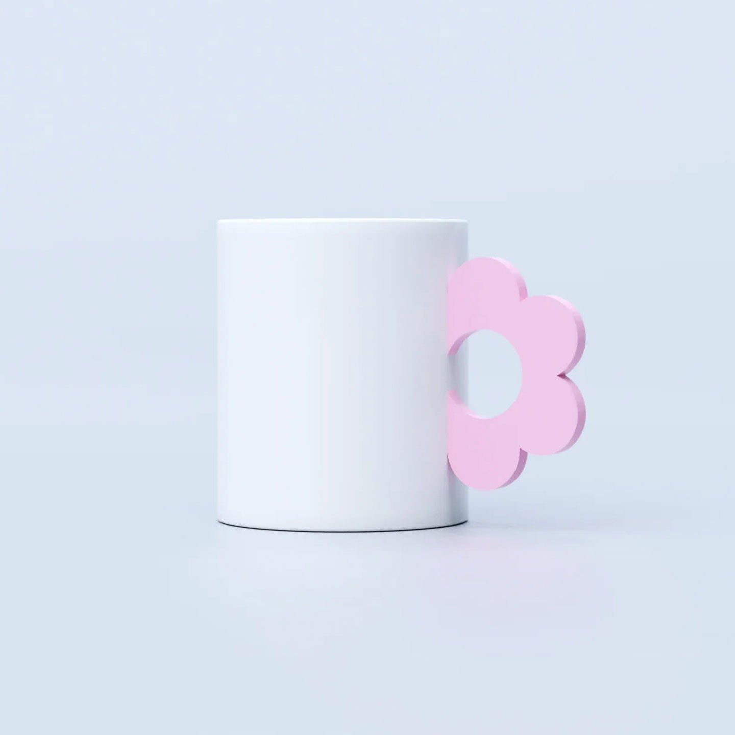 Mug en céramique avec motif floral et anse rose pastel.
