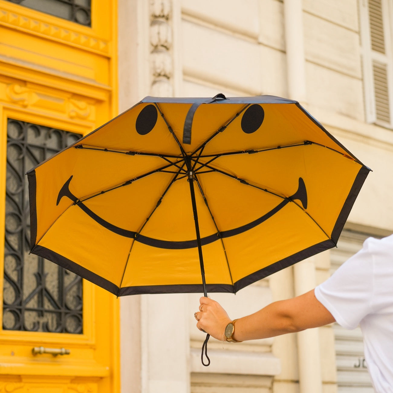 Parapluie Smiley ouvert, motif joyeux à l'intérieur.