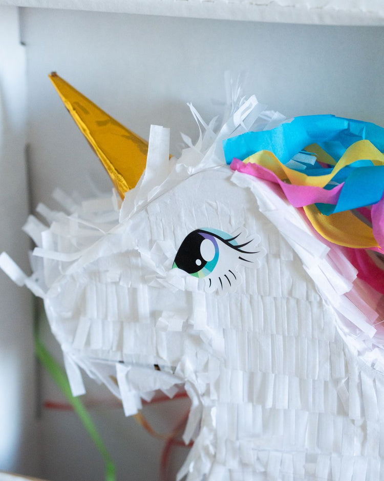 Piñata licorne colorée avec bonbons, vue de côté.