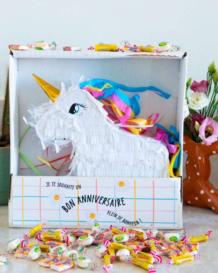 Piñata licorne colorée avec bonbons, vue de côté.