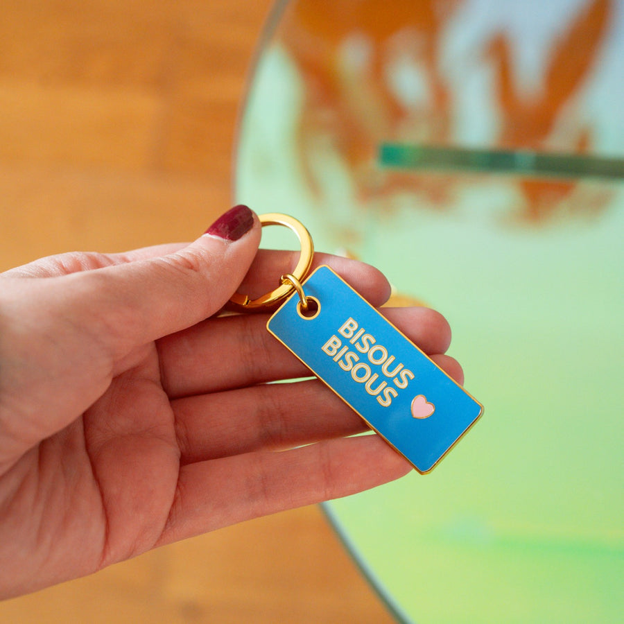 Porte-clé Bisous bisous avec cœur en relief et détails colorés.