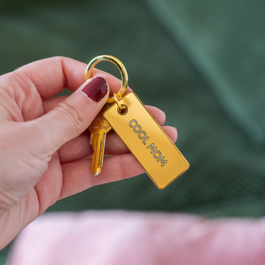 Porte-clé 'Cool Mom' avec inscription en relief sur fond clair.