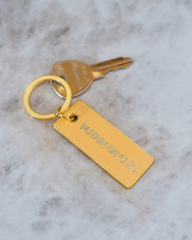 Porte-clé avec inscription humoristique sur fond clair.