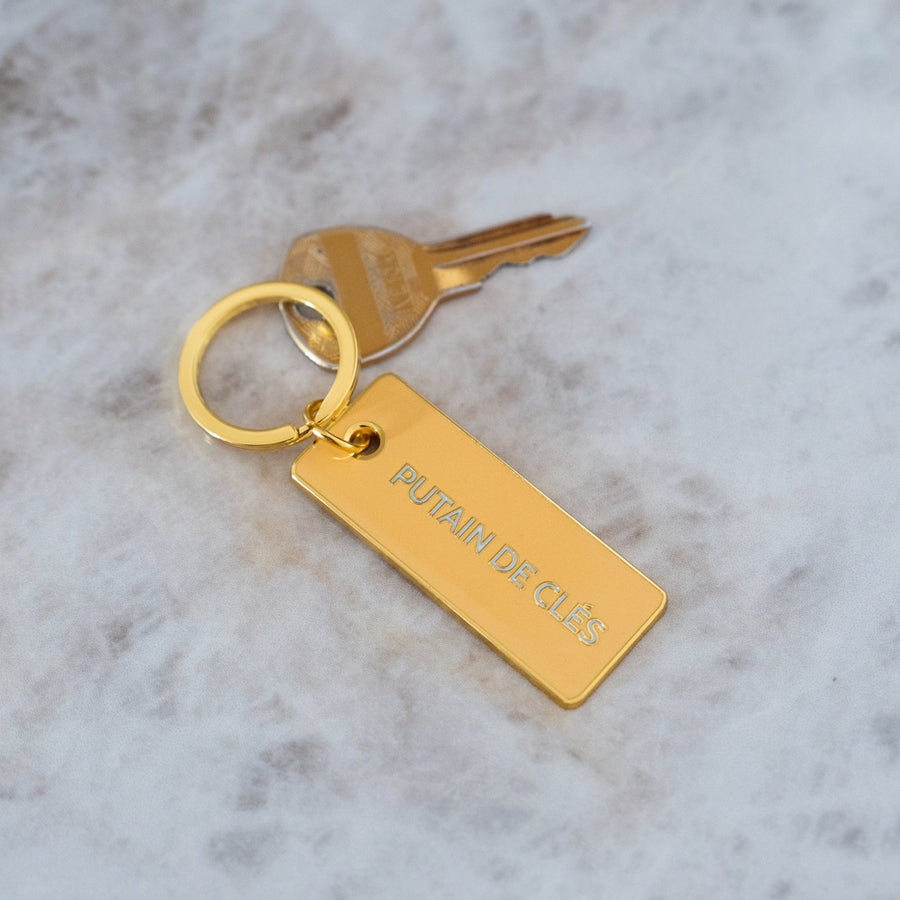 Porte-clé avec inscription humoristique sur fond clair.