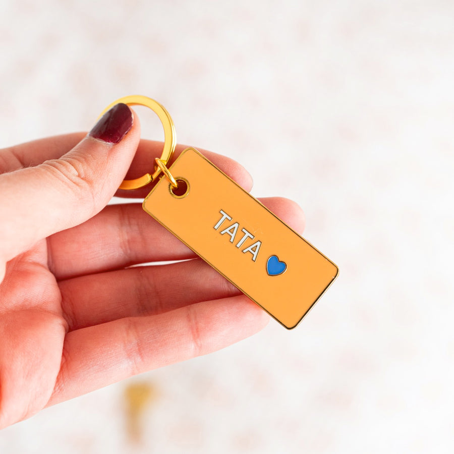 Porte-clé Tata avec un design coloré et un cœur stylisé.