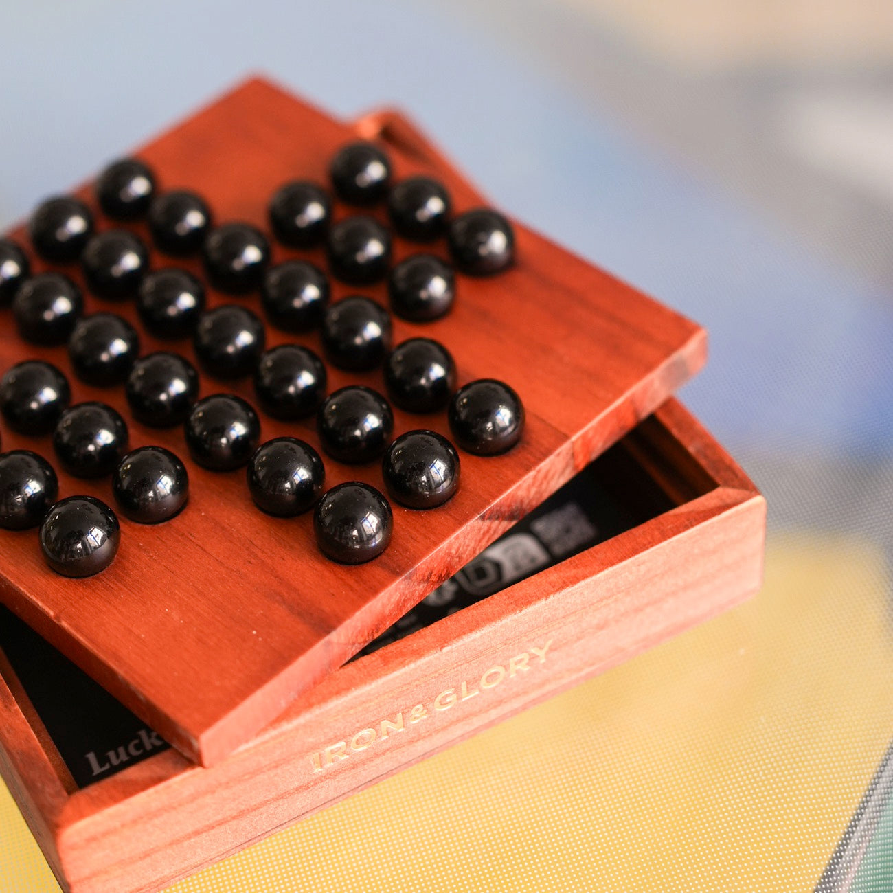 Solitaire en bois avec billes de verre sur fond clair