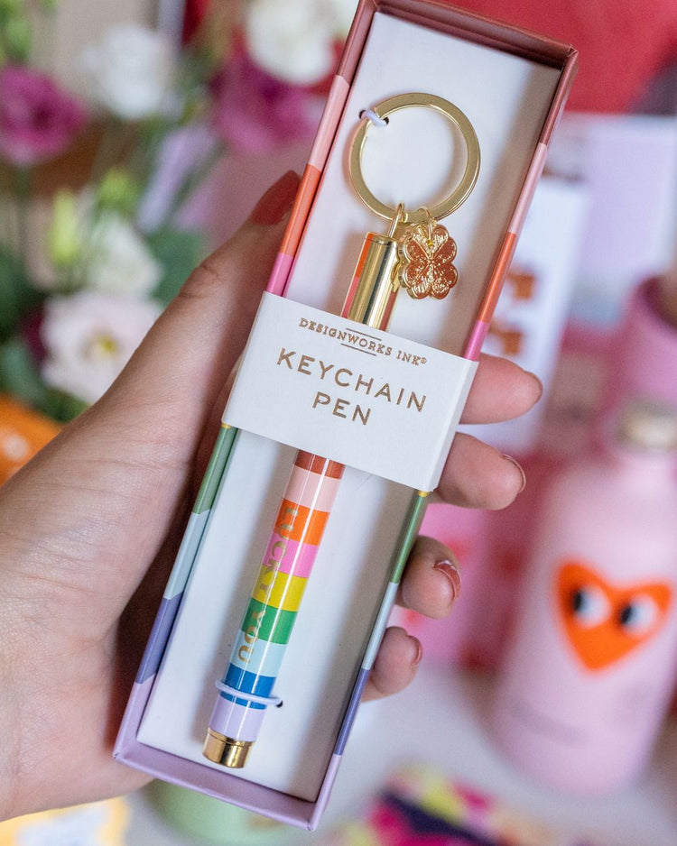 Porte-clé avec stylo rayé et trèfle doré en détail