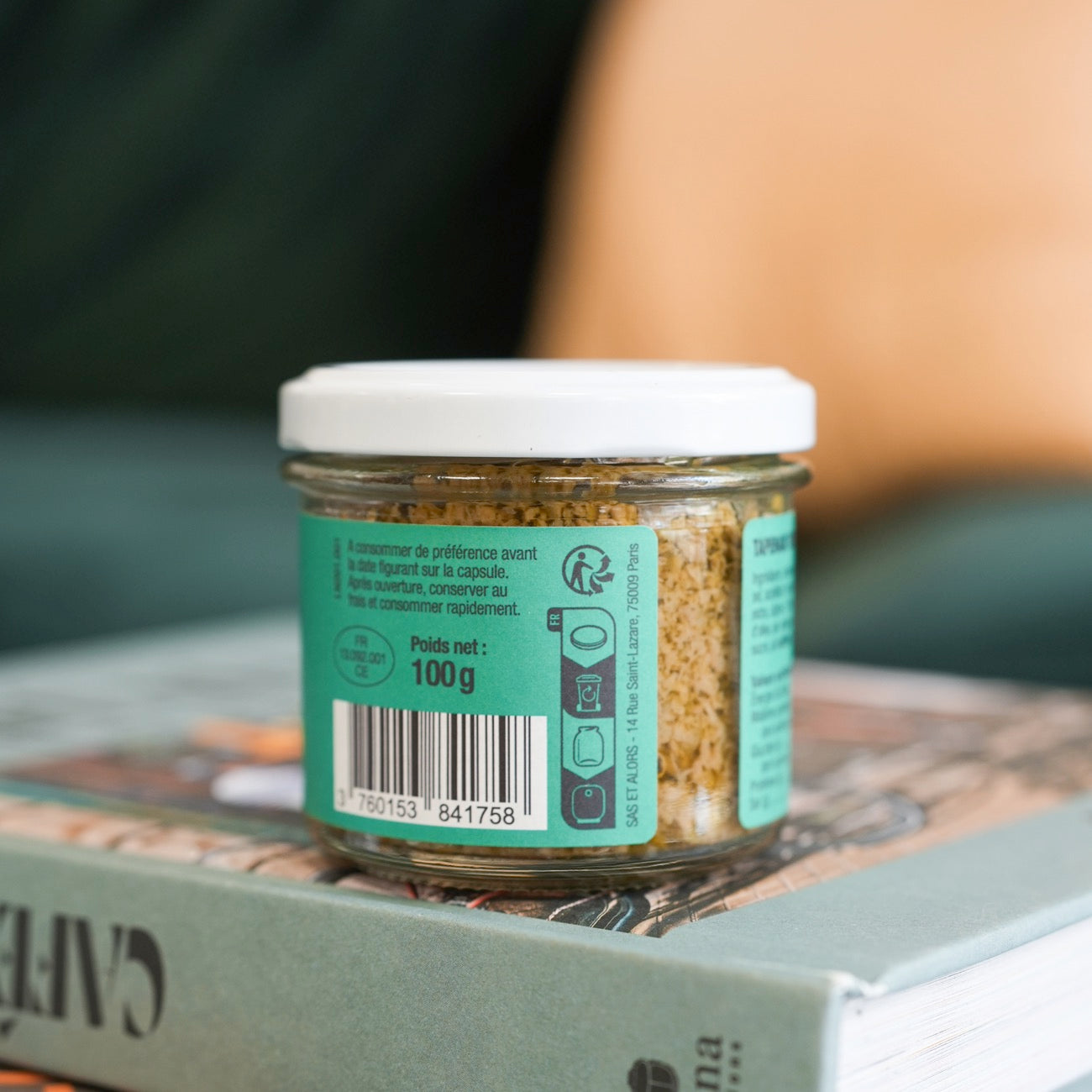 Pot de tapenade verte avec olives sur fond neutre